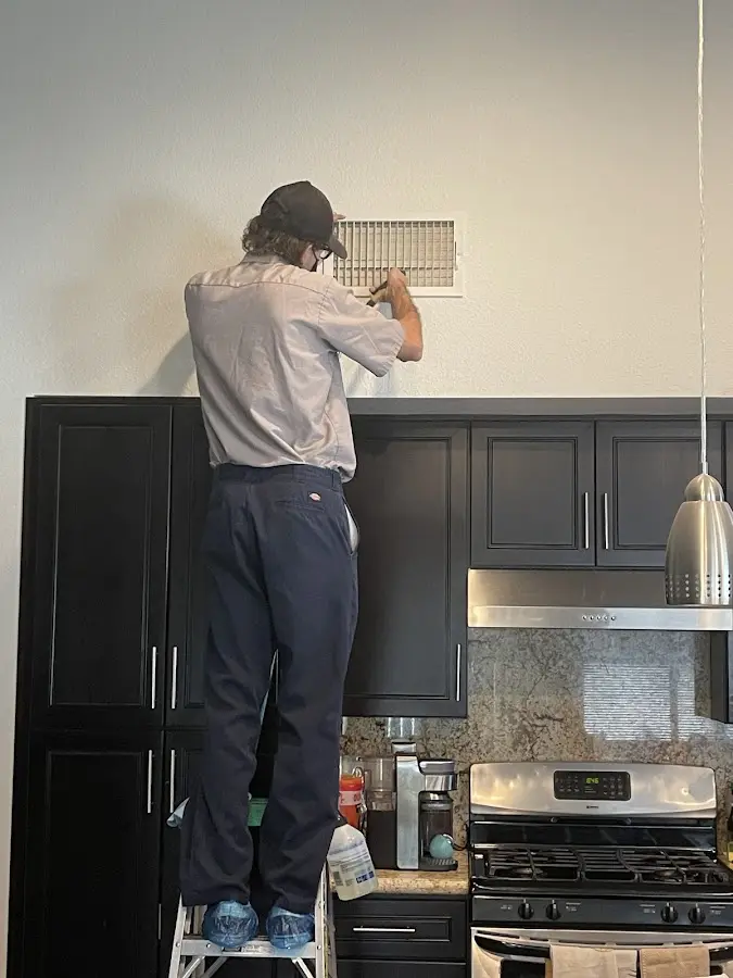 Technician inspecting an air vent during HVAC service in Berkeley